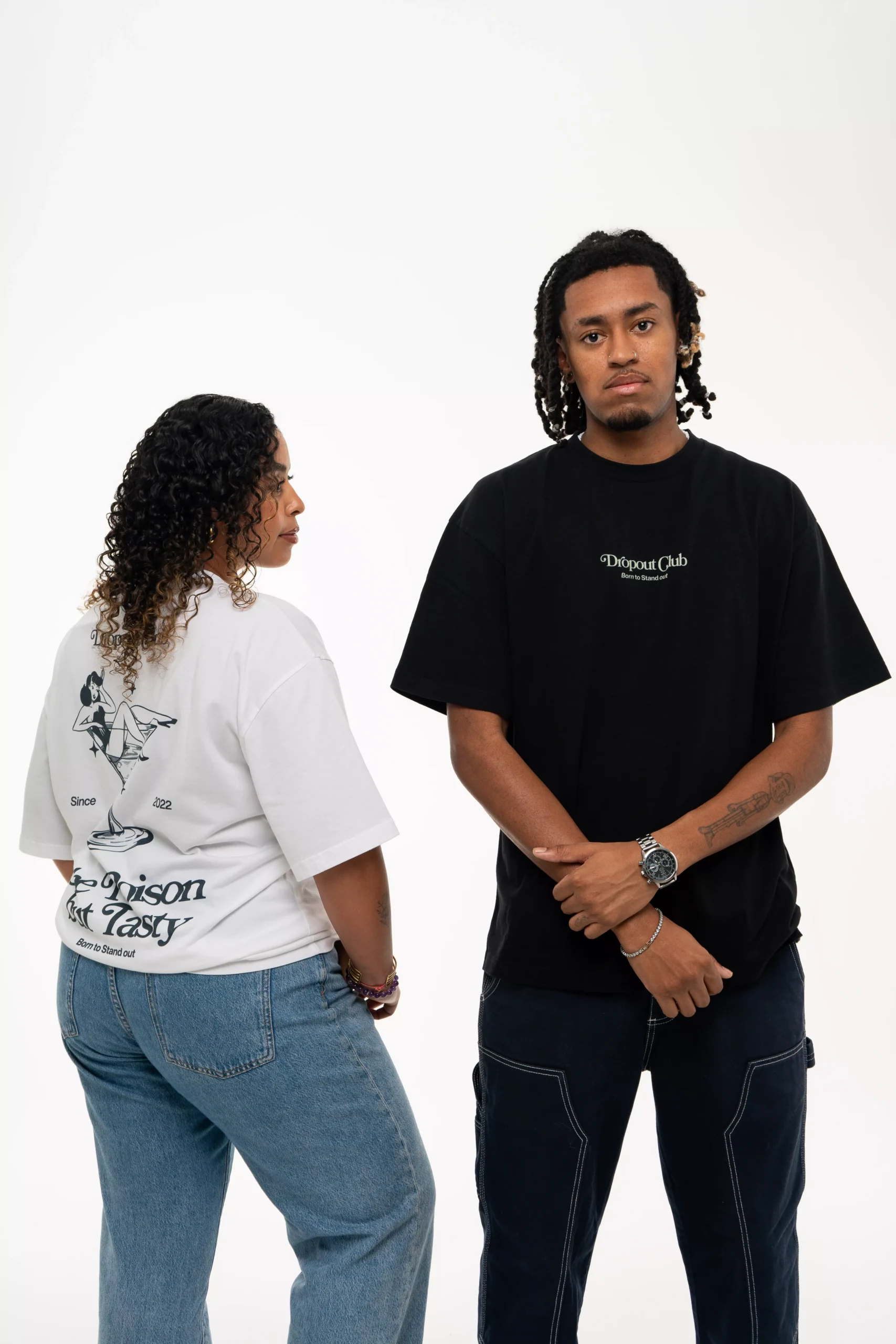 Model Júlia from the back while wearing the Tasty Poison Graphic White T-shirt by Dropout looking at model Facko from the front while he wears the Tasty Poison Graphic Black T-shirt