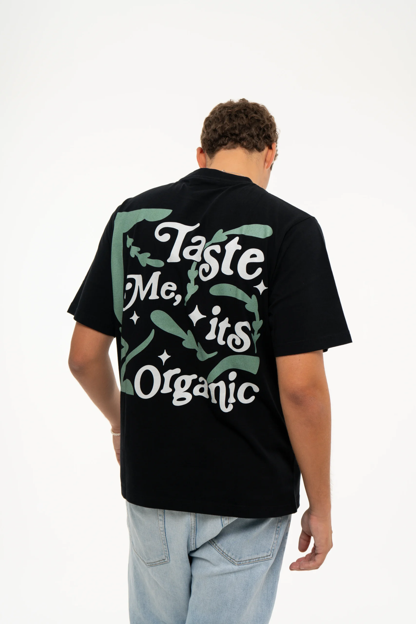 Back shot in movement of model Gustavo from the Dropout brand wearing the Organic Taste Black T-shirt