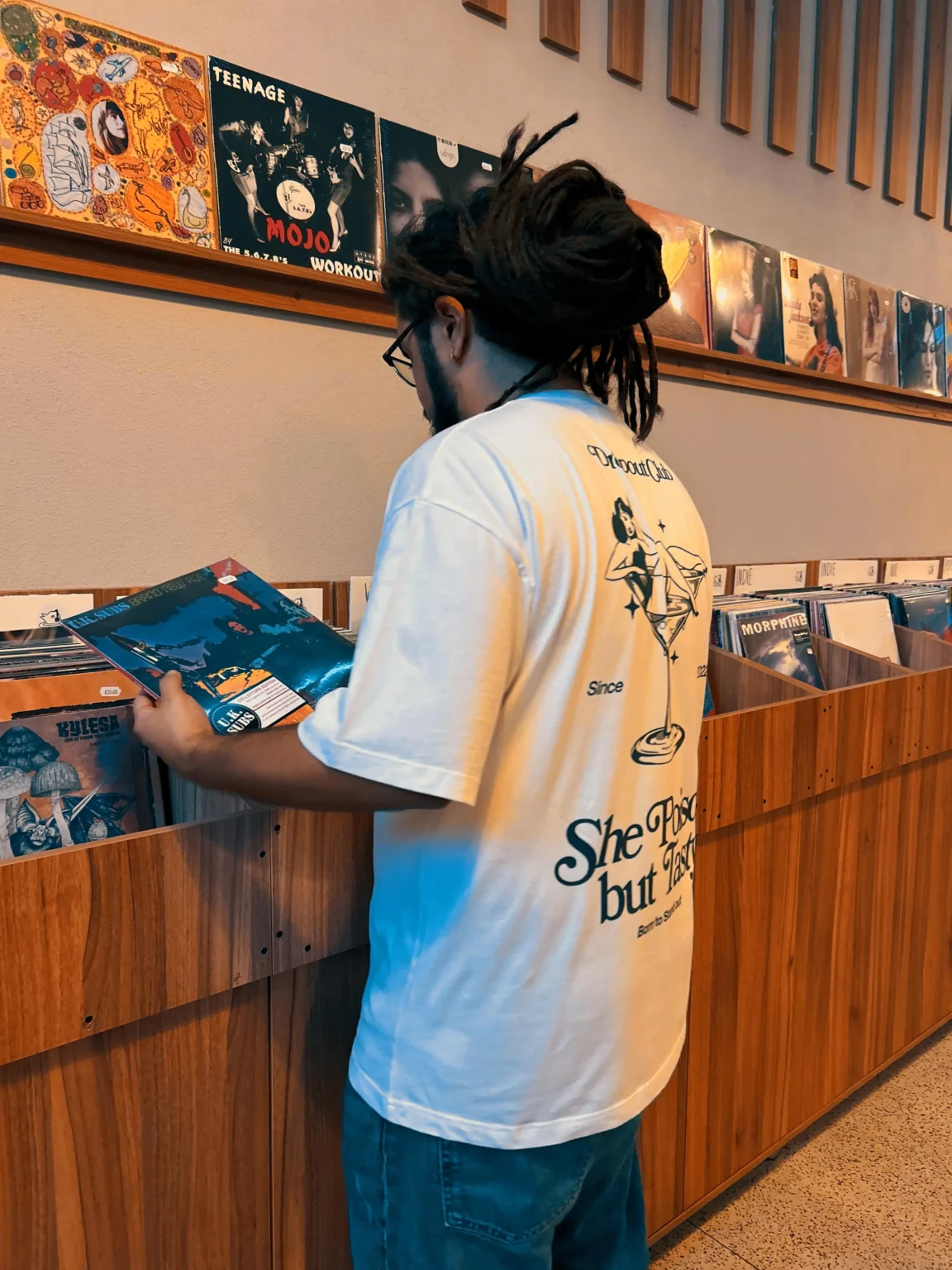 Freddy choosing Vinyls with Tasty Poison White T-shirts from the Dropout brand